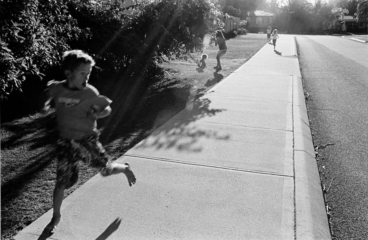 black and white photography - Australian suburbia kids playing chasey. Perth, Western Australia