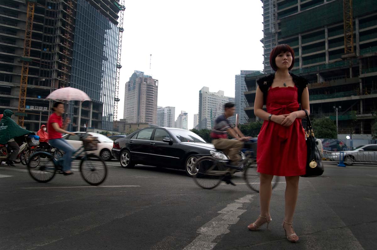 Woman in a red dress on busy city street in Chengdu, China